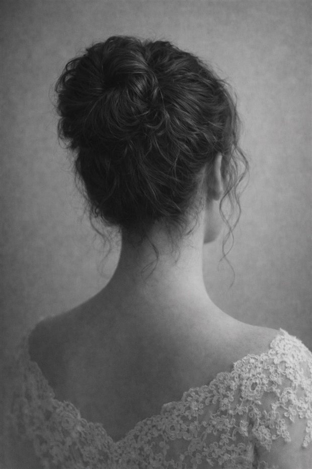 Eliza Linden, photographed from behind: dark hair pinned up, wearing lace.